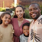 Smiling multicultural family enjoying time together outdoors in their garden.
